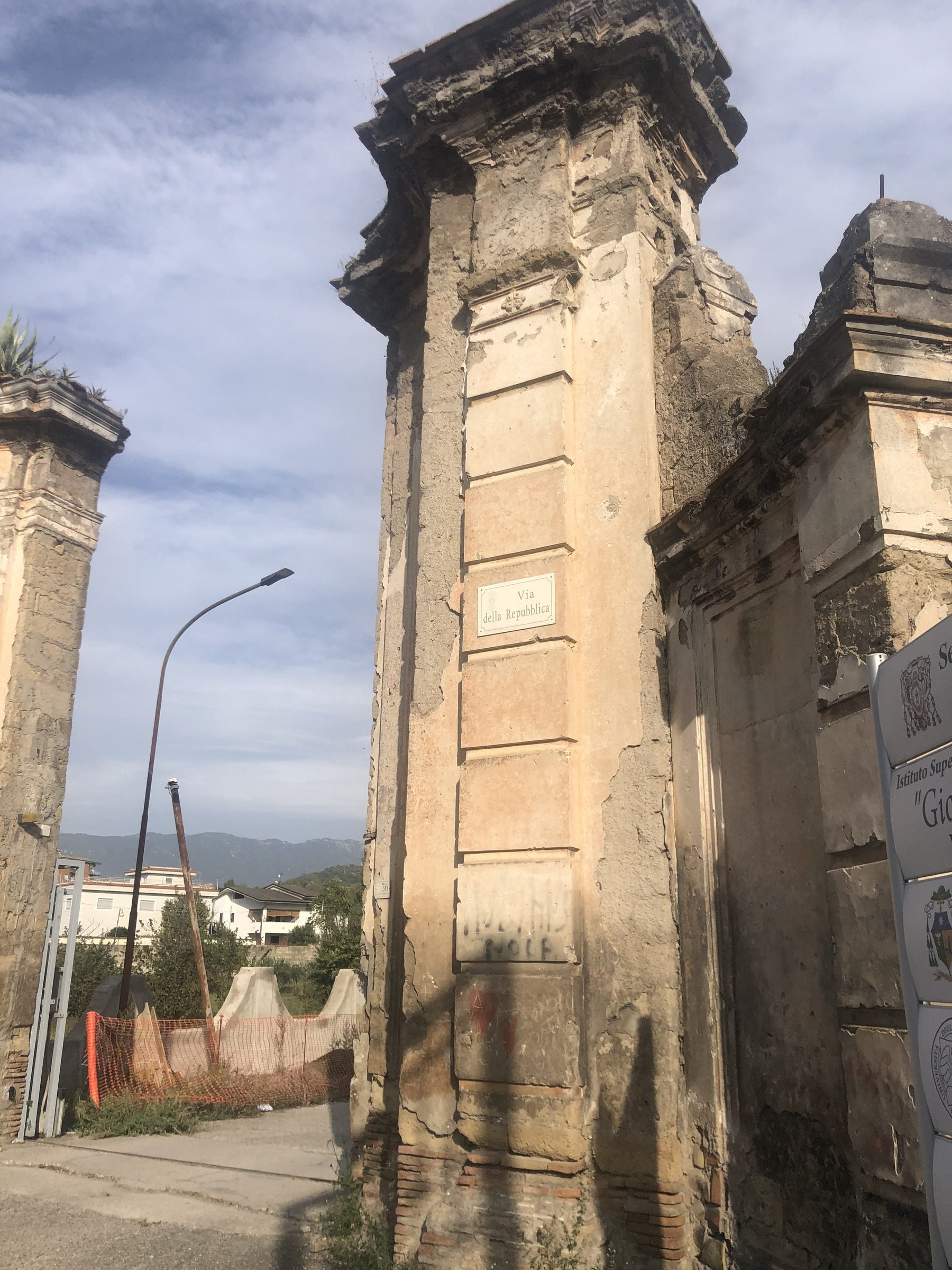 Pilastri storici in muratura del portale, degradati, con intonaco distaccato e cornici erose