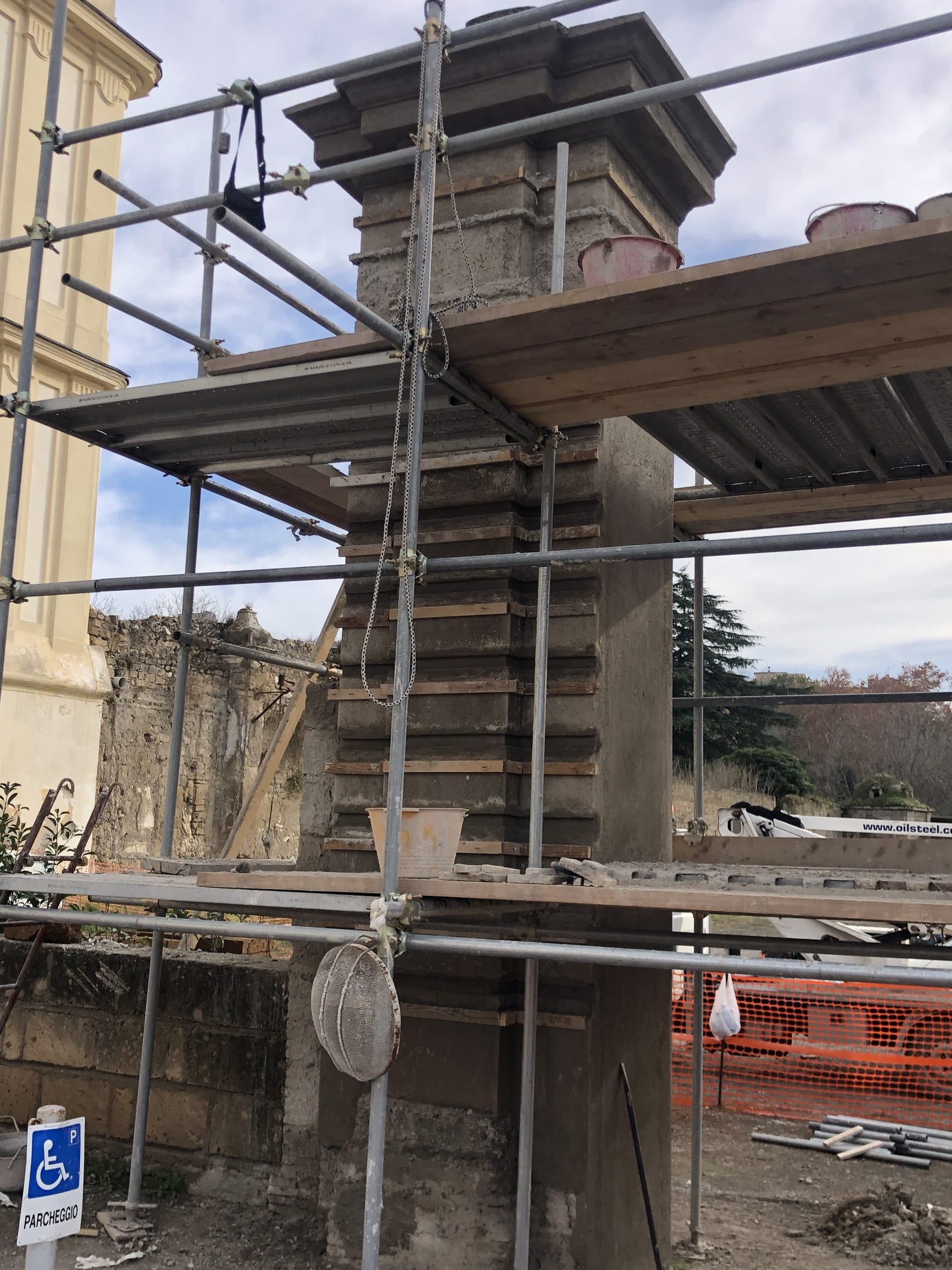 Pilastro storico del portale avvolto dal ponteggio durante i lavori di restauro